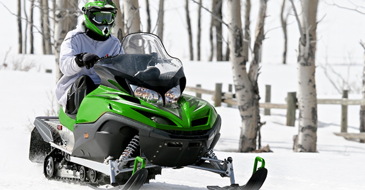 Man on a Green and Black Snow Mobile Man on a Green and Black Snow Mobile